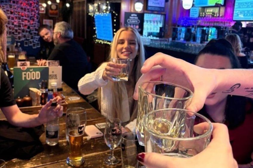 A bar with people toasting with drinks. 4
