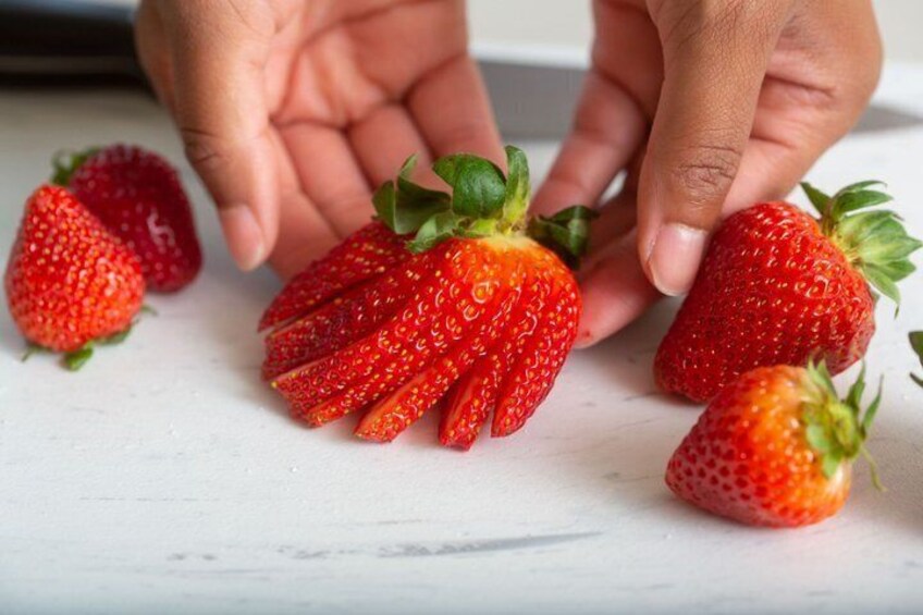 A hand holding a strawberry. 4