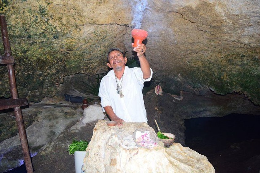 A person in a cave holding a smoking device. 3