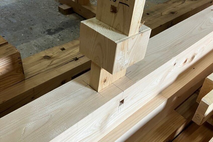 A wooden structure with a vertical support and horizontal beams, likely a part of a construction or woodworking project. 5
