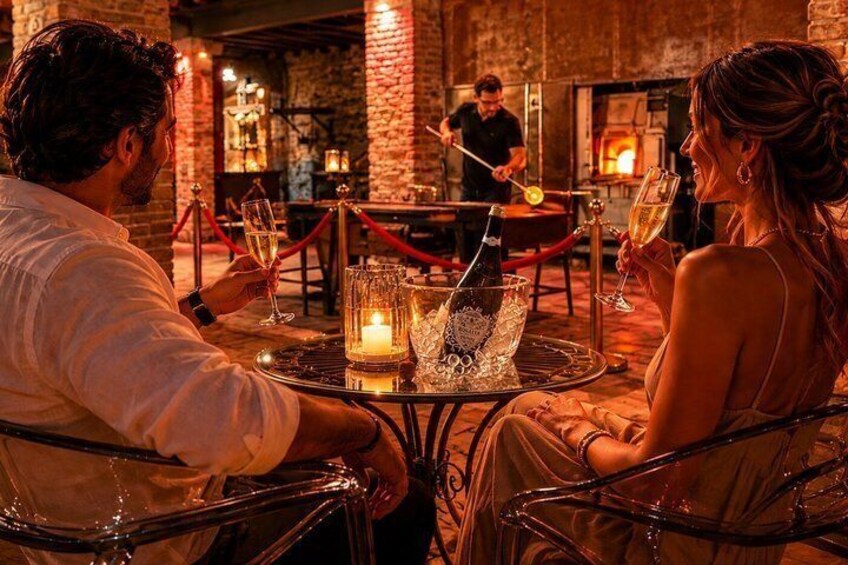 A couple dining at a table with a candle and a bottle of champagne. 1