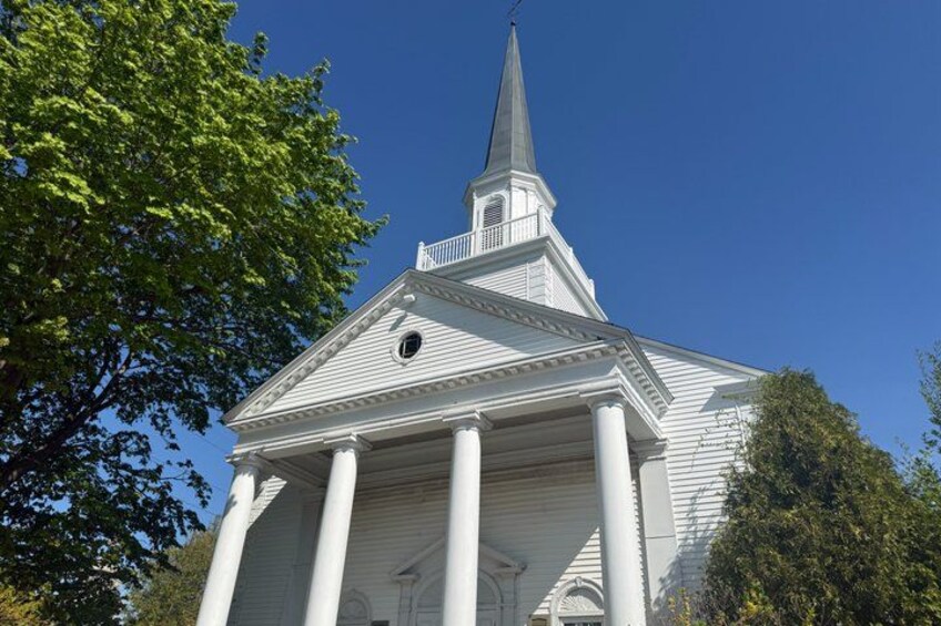 A white church with a steeple and columns. 4