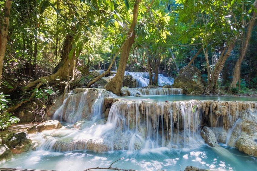 A waterfall cascading over rocks in a forested area. 2