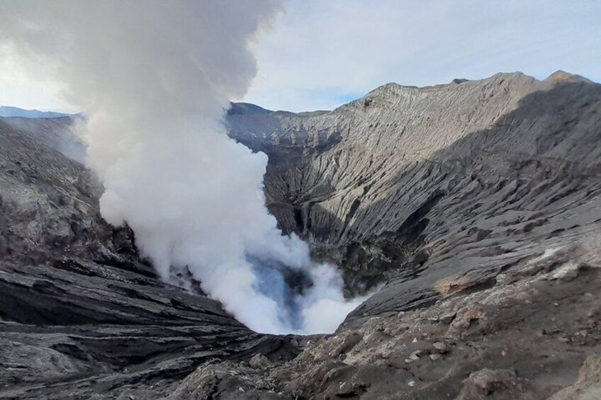 A volcanic crater with steam rising from the center. 3