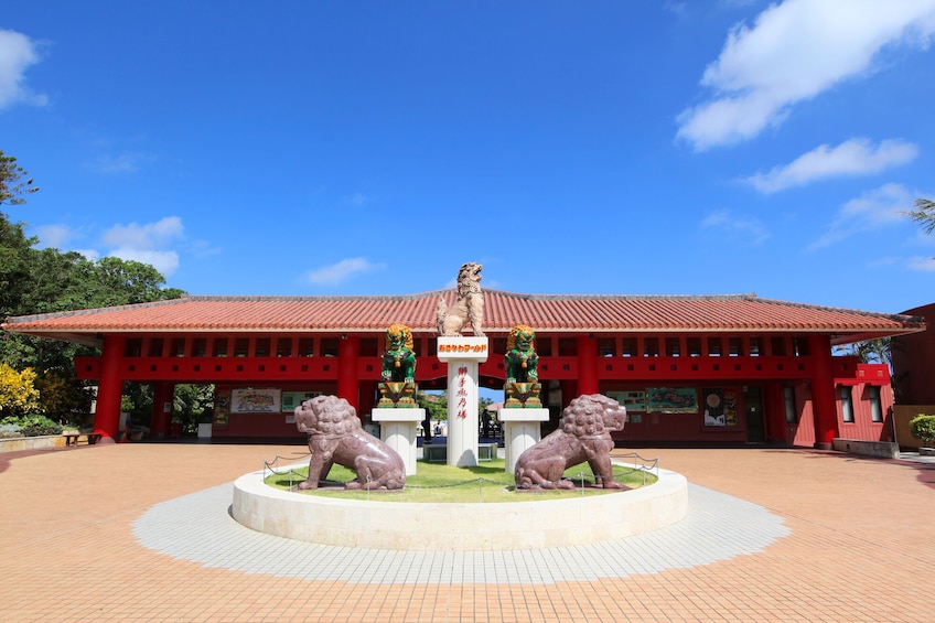 Un templo con techo rojo y dos estatuas de leones en primer plano. 1