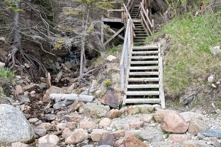 A wooden staircase leading up a rocky hillside. 4