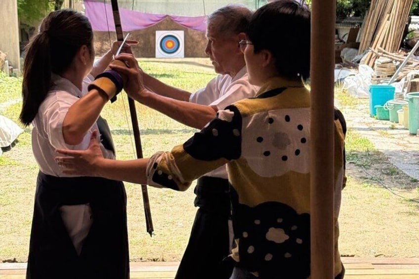 A person drawing a bow, aiming at a target. 4
