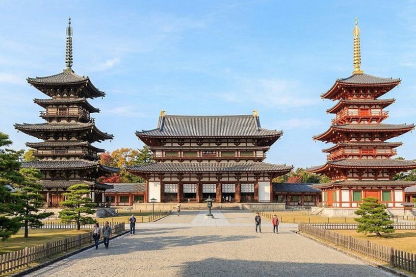 Un templo japonés tradicional con varias pagodas, un edificio central imponente y un patio de grava. 5