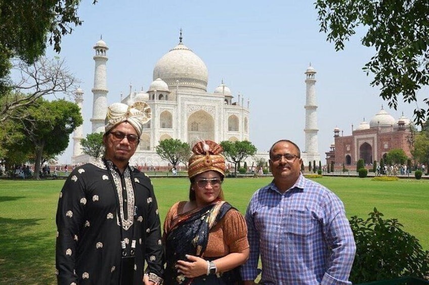 Three people standing in front of the Taj Mahal. 4