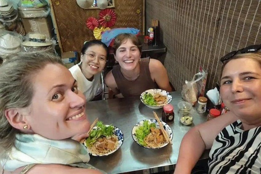 Un gruppo di persone sedute a un tavolo con cibo e bevande. 2