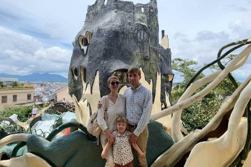 A family posing in front of a dinosaur sculpture with a slide. 2