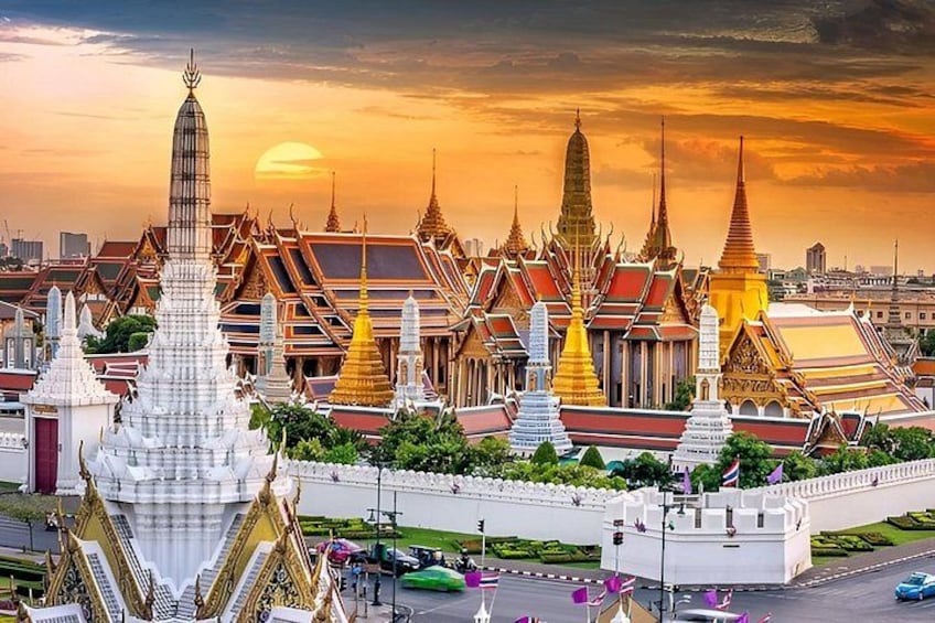 A temple complex with ornate spires and golden roofs, surrounded by a white wall and a road with vehicles. 4