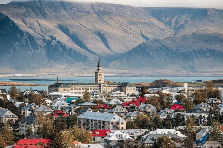 A town with a prominent church, a lake, and mountains in the background. 3