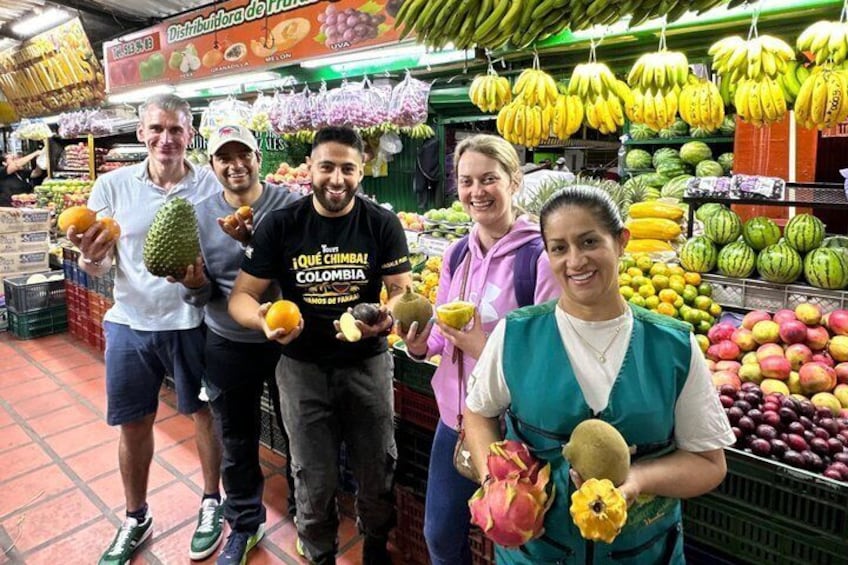 A group of people in a grocery store holding various fruits. 1