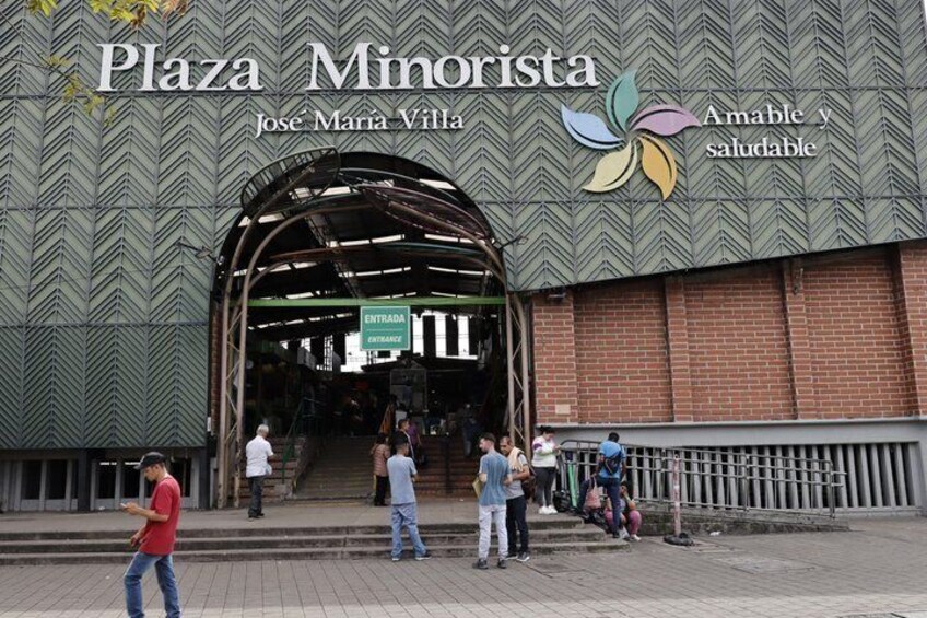 Plaza Minorista with a large entrance and people walking around. 3