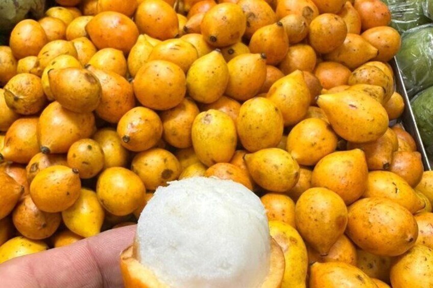 A pile of yellow fruits with a hand holding a white object. 4