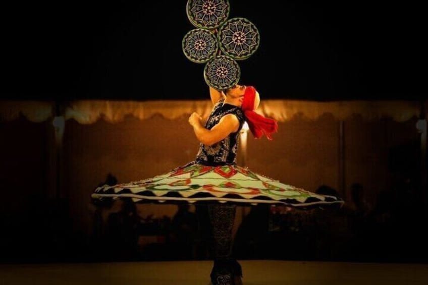 A person performing a dance with a patterned skirt and a headpiece. 3