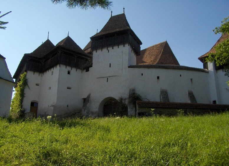 A historic building with multiple towers and a central arched entrance. 3