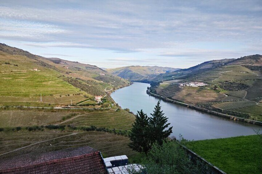 A river winding through a valley with terraced fields and a small building near the water's edge. 4
