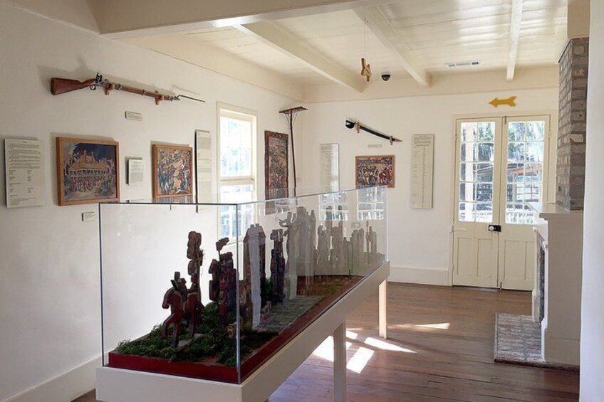 A museum interior with glass display cases, wooden floors, and various historical artifacts. 5