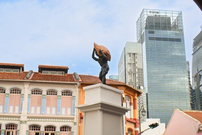 A statue of a person holding an umbrella, a traditional building, and a modern skyscraper. 4