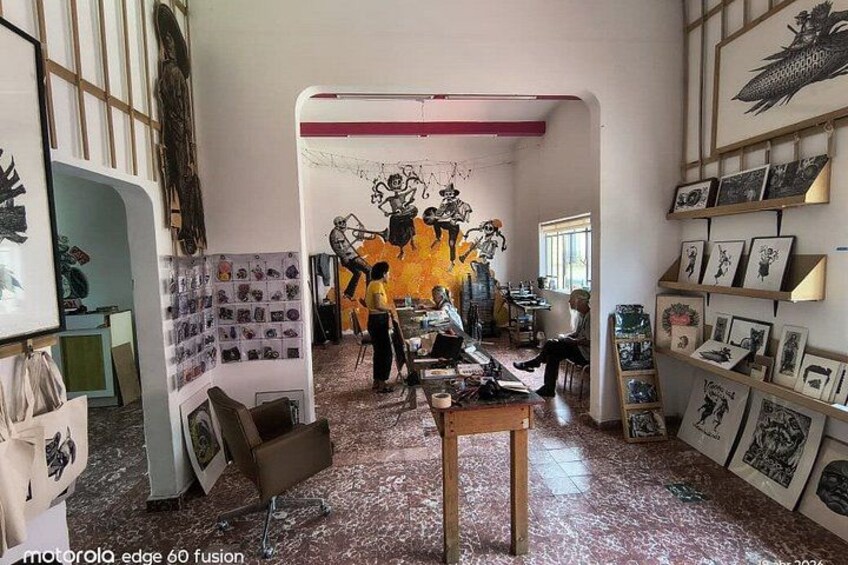 An art gallery with various artworks displayed on walls and tables. 1