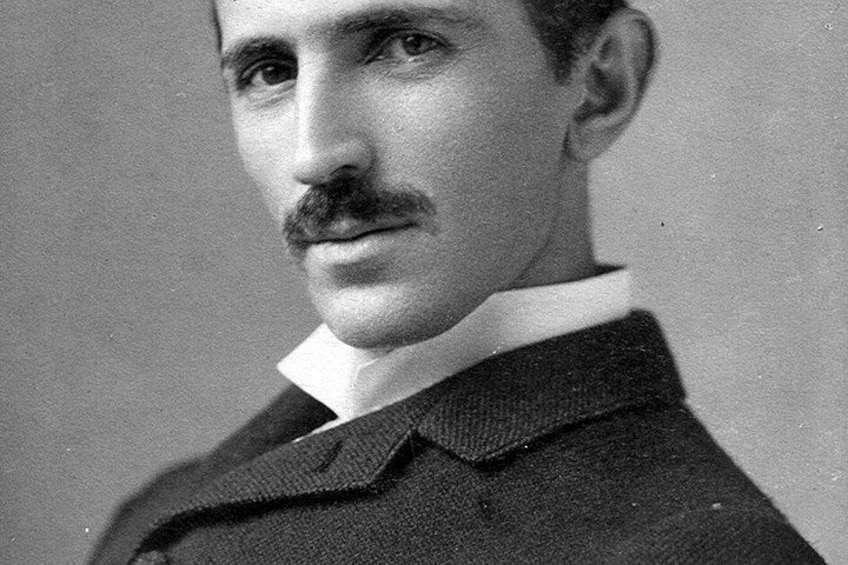 A person wearing a dark suit with a white shirt and a dark tie. 1