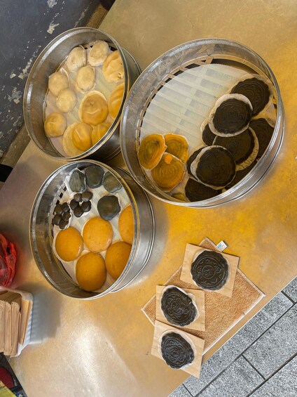 Three metal trays with various baked goods, some wrapped in paper. 2