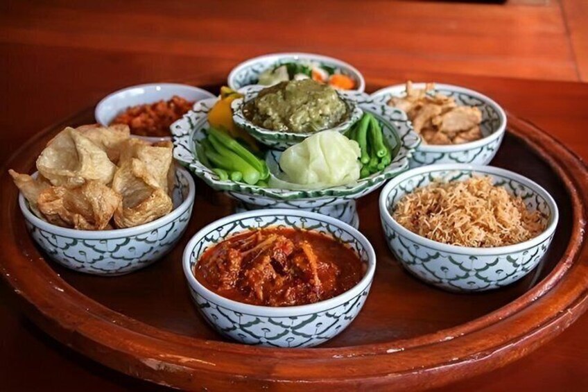 A tray with various bowls of food, including what appears to be fried items, vegetables, and sauces. 5