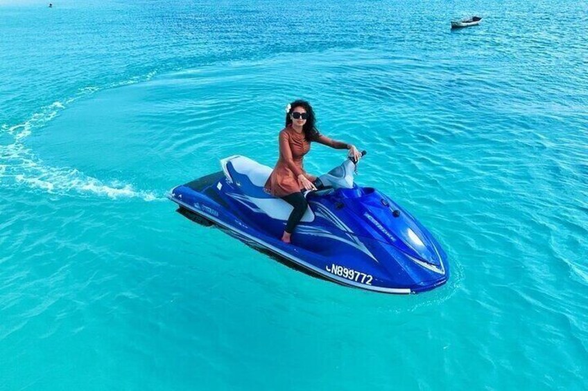 A person riding a jet ski on turquoise water. 1