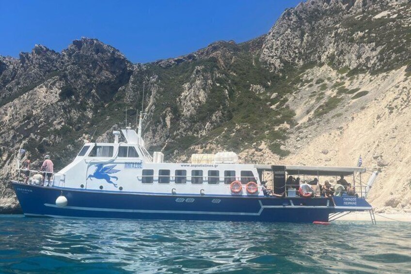 A boat with a dragon logo, named 'Tierra del Sol,' docked near rocky cliffs. 2