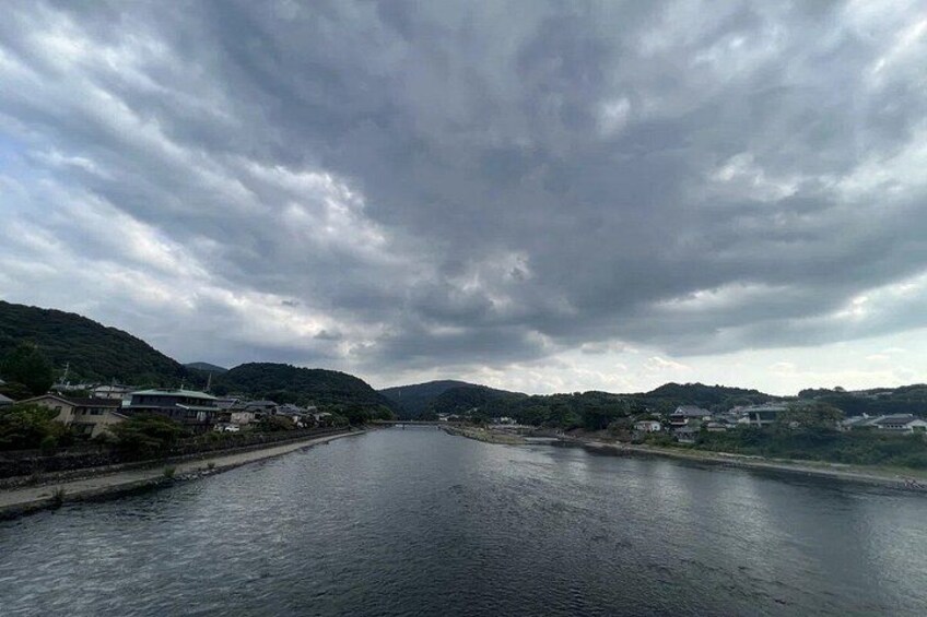 A river with buildings on the banks, under a cloudy sky. 5