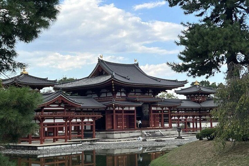 A traditional Japanese building with multiple gabled roofs, surrounded by a pond and trees. 4