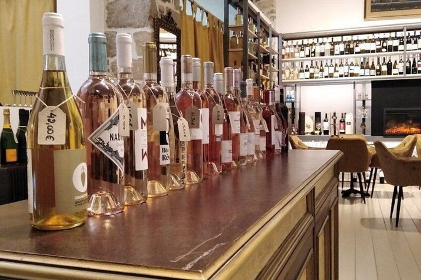 A bar with bottles of wine and spirits on shelves and a fireplace in the background. 2