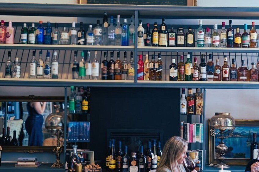 A bar with shelves of various liquor bottles. 4