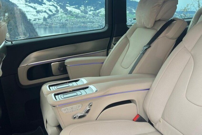 Ein Auto-Innenraum mit beigen Ledersitzen, einem Schiebedach und Blick auf eine verschneite Landschaft durch die Fenster. 3