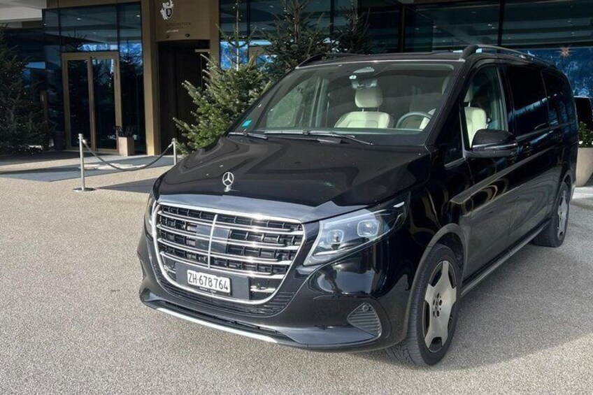 Ein schwarzer Mercedes-Benz SUV vor einem Gebäude mit Glastüren. 5