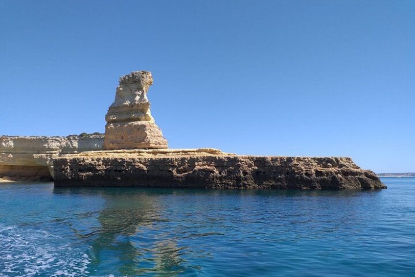 A coastal rock formation with a prominent pillar-like structure. 5