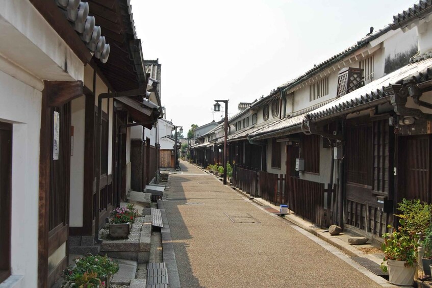 A narrow street lined with traditional buildings, featuring wooden facades and tiled roofs. 1