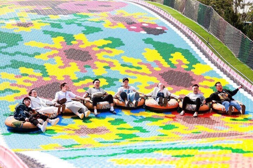 People sliding on tubes on a colorful slide. 5