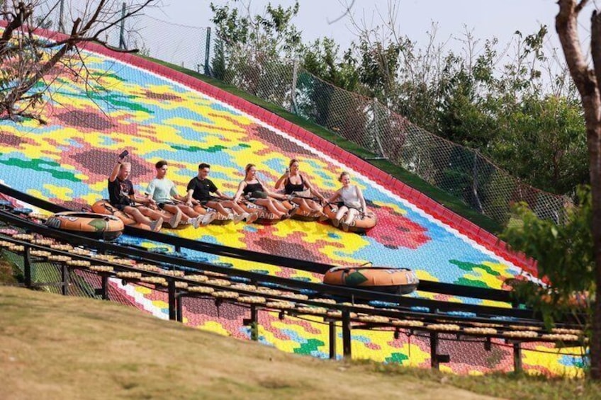 People sliding down a colorful slide with a floral pattern. 2
