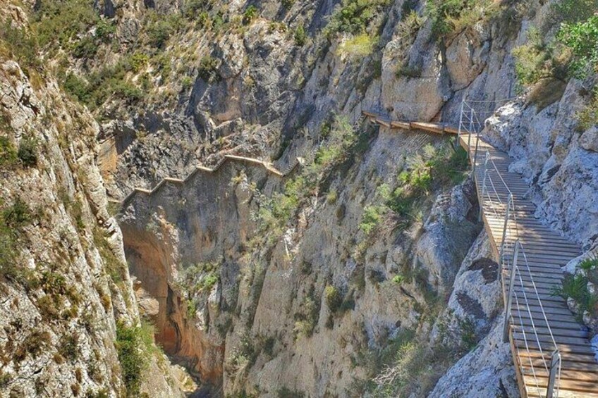 A wooden staircase descending a steep rocky cliff. 2