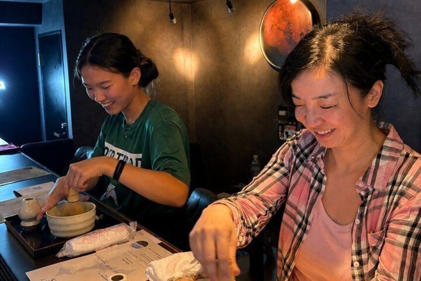 Two people at a table with bowls and chopsticks, likely preparing or eating a meal. 5