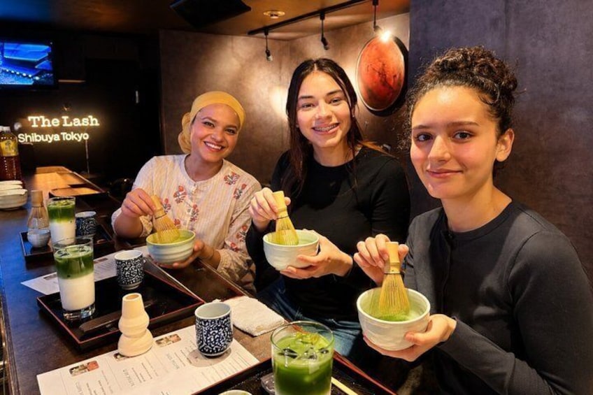 Three people at a bar with shoyu tea and a menu. 4