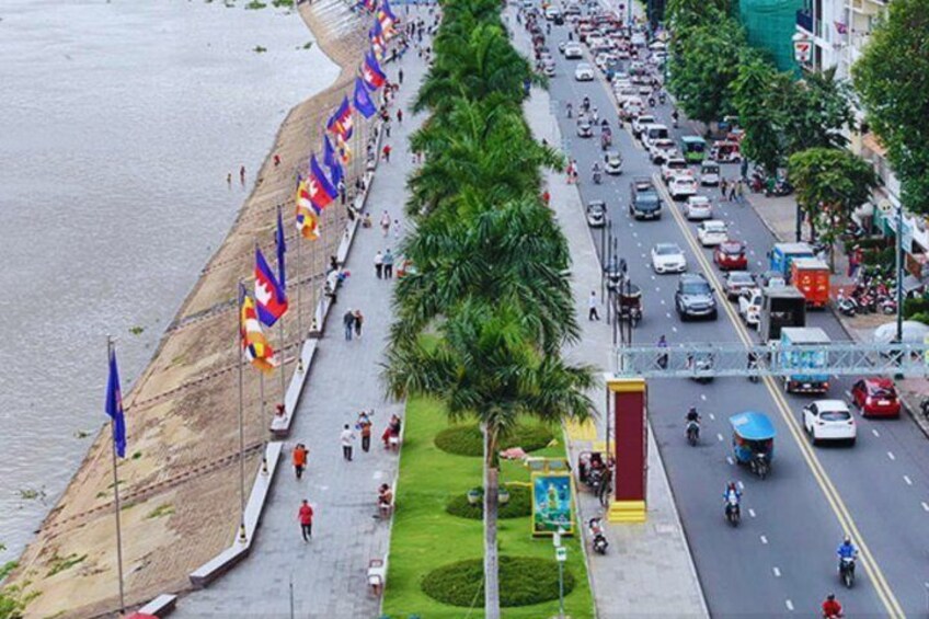 A coastal road lined with flags, a beach, and a busy street with vehicles and pedestrians. 5