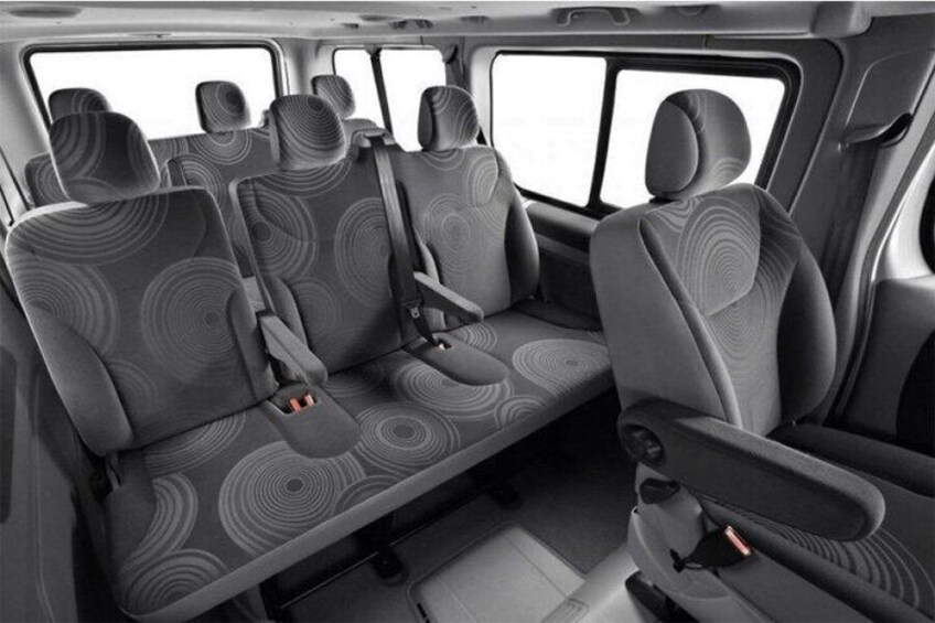 A vehicle interior with patterned seats and a central aisle. 4