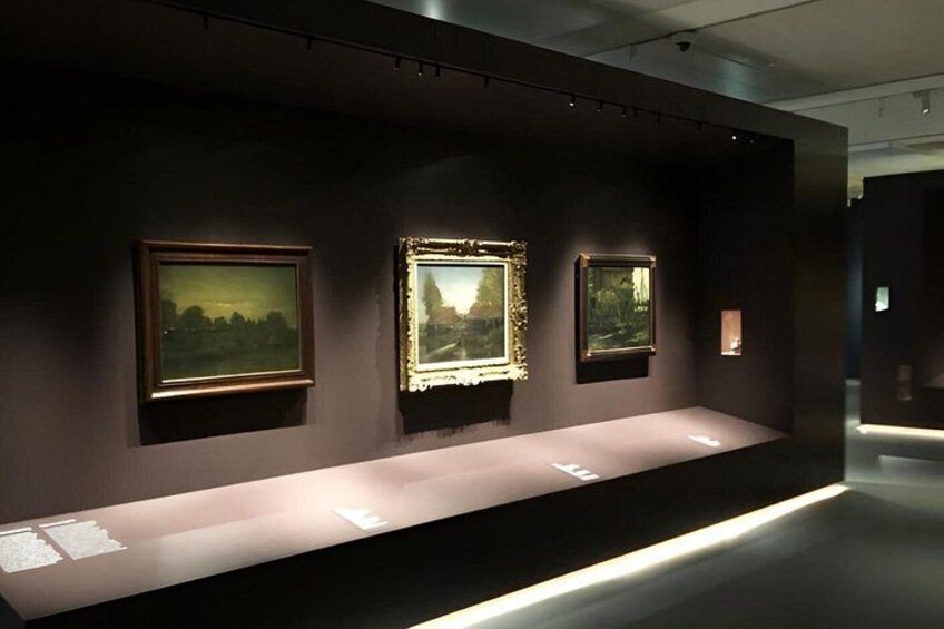 A gallery with framed paintings on display. 4