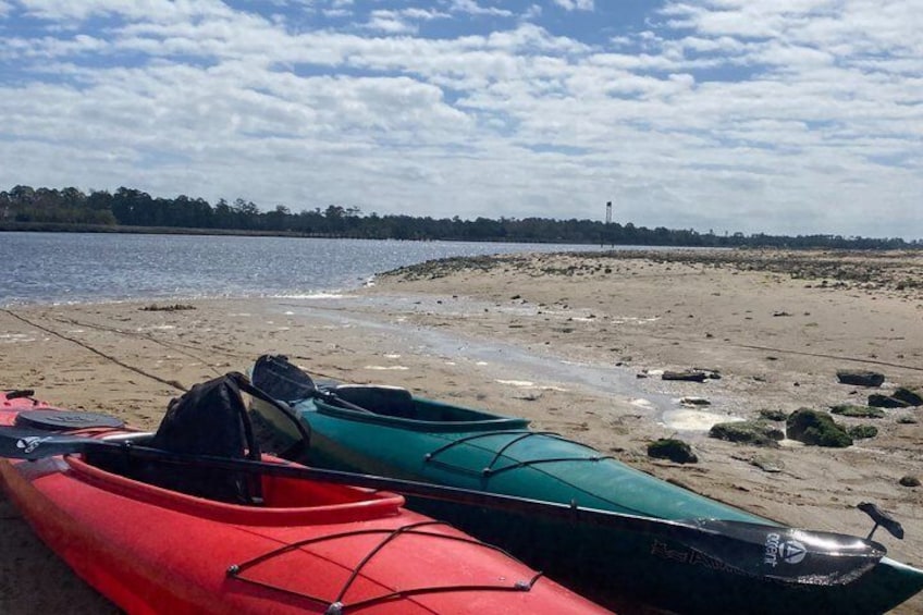 Two kayaks on a sandy beach with a calm body of water and a cloudy sky. 5