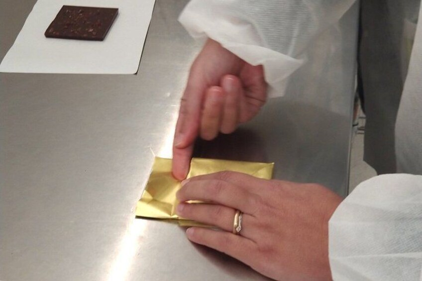 A person folding a piece of paper. 3