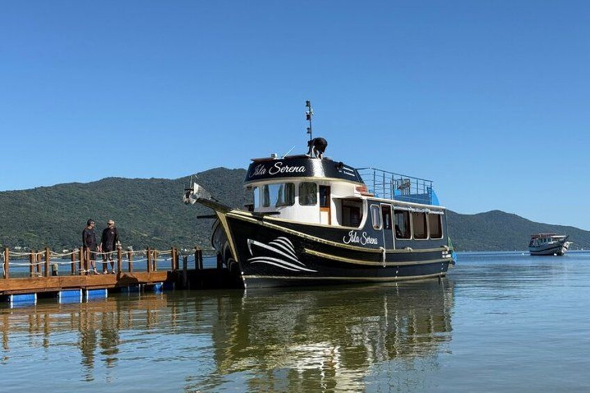 A boat named 'La Serena' docked at a pier with a mountainous backdrop. 4
